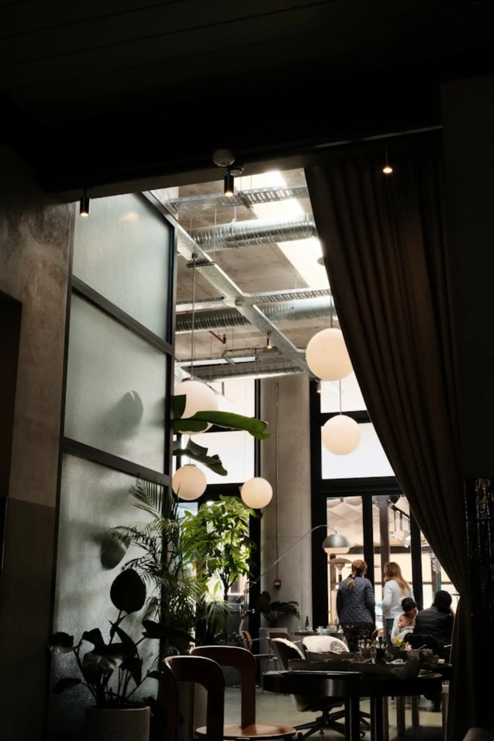 Editorial hospitality interior — atrium lobby with pendant lights and floor-to-ceiling windows